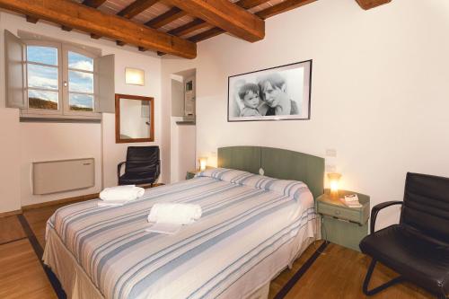 a bedroom with a large bed and two chairs at Coldimolino Resort in Gubbio