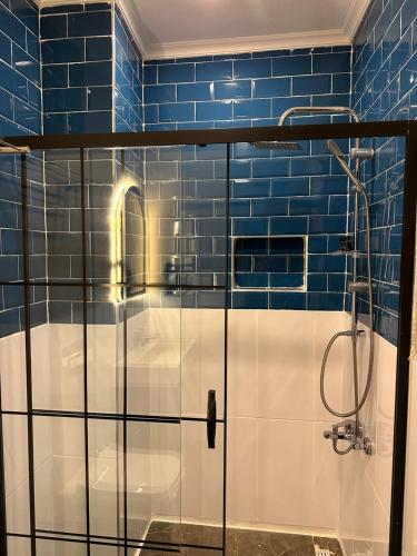 a bathroom with a shower with blue tiles at Loft Park Hotel's in Arnavutköy