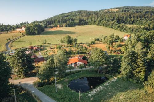 an aerial view of a village with a house and a pond at RESZTÓWKA in Polanica-Zdrój