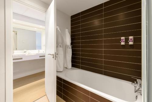 a bathroom with a bath tub and a sink at FERGUS Club Palmanova Park in Palmanova