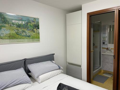 a bedroom with a bed and a painting on the wall at in&out apartment - mostacciano, eur in Rome