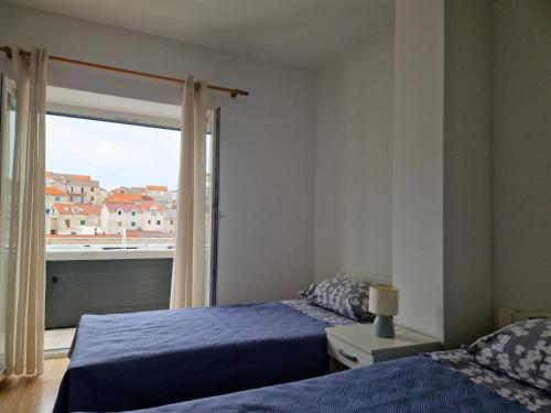 a bedroom with two beds and a window at Apartment Mladinić Muse in Pučišća