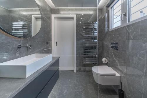 a bathroom with a sink and a toilet and a mirror at The HostMaster Luminous Elite Estate in Athens