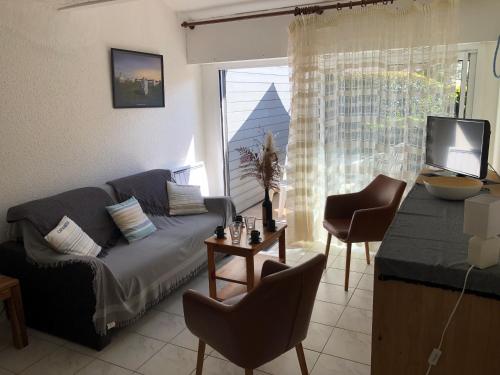 un salon avec un canapé, une table et une télévision dans l'établissement PORT AN DRO - Studio avec Terrasse, Wifi - UD98, à Carnac
