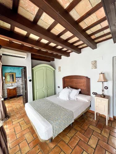 卡莫納的住宿－Hotel Servilia，一间卧室配有一张大床和木制床头板