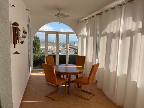 a dining room with a table and chairs and a window at CHALET INDEPENDIENTE COn VISTAS AL MAR in Peniscola