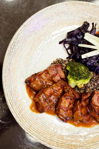 a plate of food with meat and broccoli on a table at Hilly Hotel in Edirne