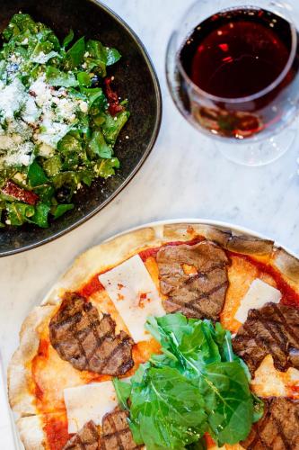 a table with two plates of pizza and a salad at Hilly Hotel in Edirne