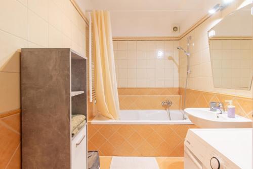 a bathroom with a tub and a sink and a toilet at Viky's Apartment in Győr