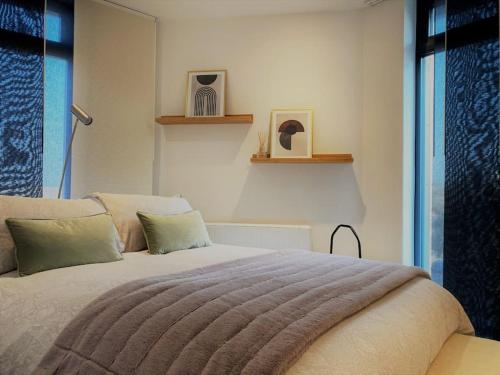 um quarto com uma cama grande e uma janela em THE PAD by the beach Penthouse apartment with sunset and city views em Bournemouth