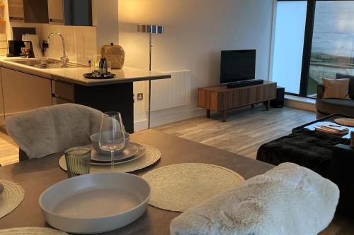 uma cozinha e uma sala de estar com mesa e cadeiras em THE PAD by the beach Penthouse apartment with sunset and city views em Bournemouth