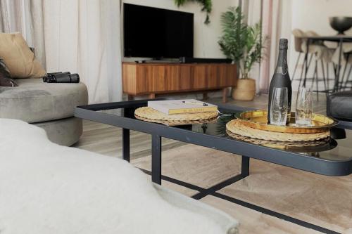 a living room with a coffee table with a bottle of wine at THE PAD by the beach Penthouse apartment with sunset and city views in Bournemouth
