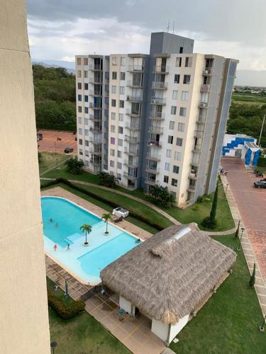 - une vue sur la piscine en face d'un bâtiment dans l'établissement Apto en Flandes Tolima., à Flandes