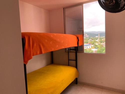 Ce lit superposé se trouve dans un dortoir doté d'une fenêtre. dans l'établissement Apto en Flandes Tolima., à Flandes