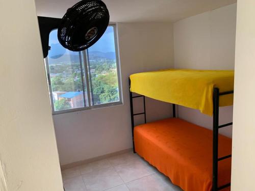 - une chambre avec des lits superposés et une fenêtre dans l'établissement Apto en Flandes Tolima., à Flandes