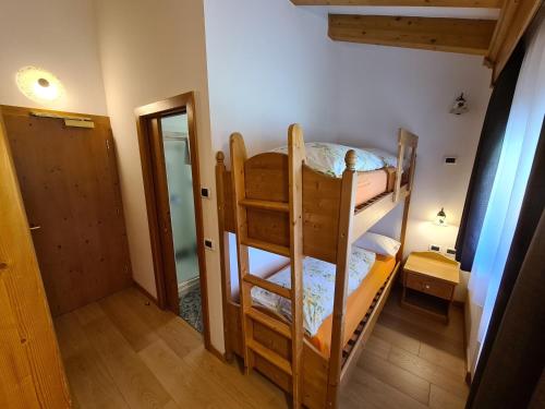 a room with two bunk beds and a hallway at Alpenhotel Panorama in Campitello di Fassa