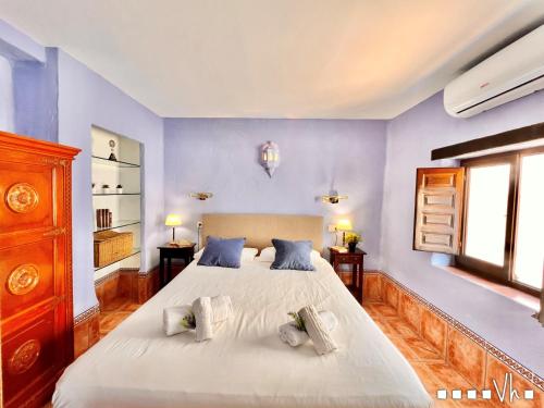 um quarto com uma grande cama branca com paredes azuis em VH CostaBlanca - APARTAMENTO RIVIERA em Moraira