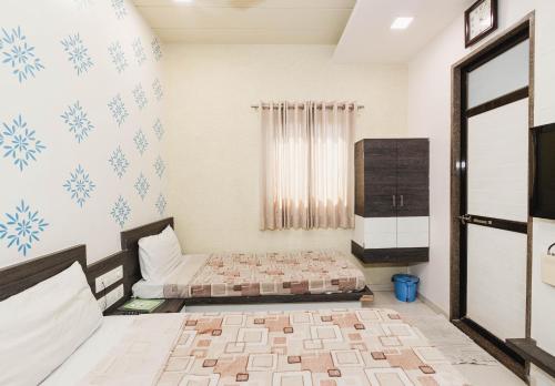 a bedroom with two beds and a tv at Hotel Amber Railway station in Vadodara