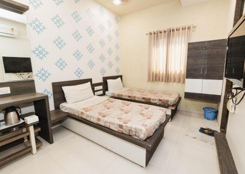 a bedroom with two beds in a room at Hotel Amber Railway station in Vadodara