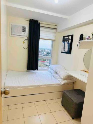 Condo in Ortigas (Kimea Suite) في مانيلا: غرفة نوم صغيرة بها سرير ونافذة