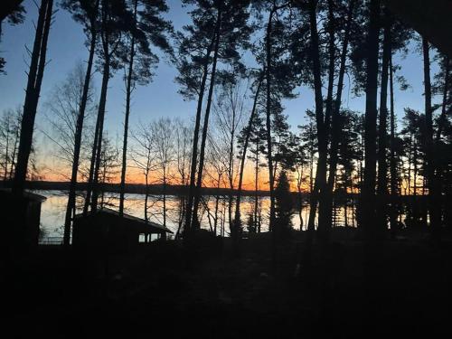 a sunset over a body of water with trees at Siemianówka in Siemiany