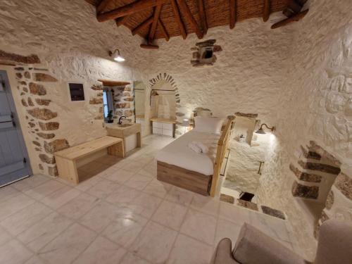 a bedroom with a bed in a stone wall at Marianta house in Areopolis