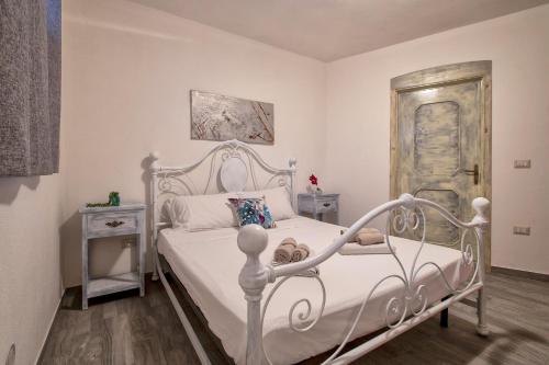 a bedroom with a white bed and a door at Appartamento Tergu in Tergu
