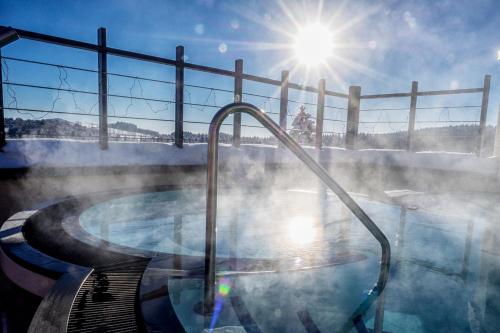 a hot tub with steam coming out of it at Wellness & Naturresort Reischlhof in Wegscheid