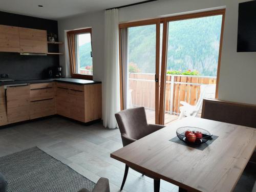 uma sala de estar com uma mesa de madeira e uma cozinha em Innerpasthof 