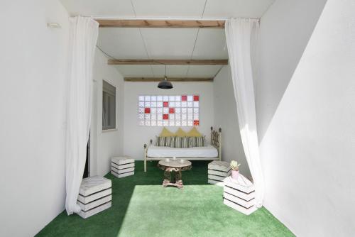 ein Wohnzimmer mit einem Sofa und einem grünen Teppich in der Unterkunft Casa de Aloe in Paderne