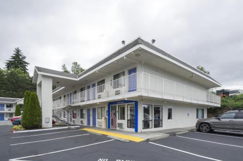 a building with a car parked in a parking lot at Motel 6-Seattle, WA - Airport in SeaTac
