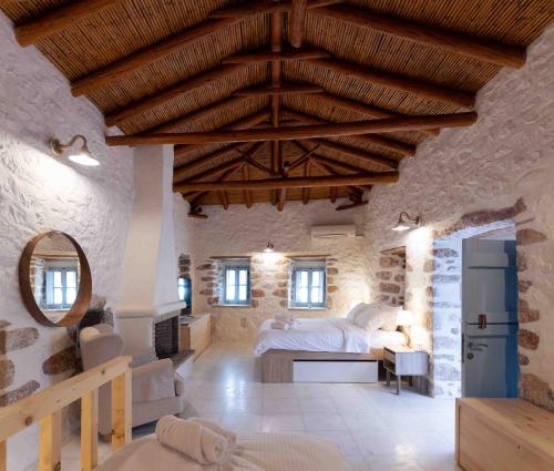 ein Schlafzimmer in einem Steinhaus mit einem Bett und einem Spiegel in der Unterkunft Marianta house in Areopoli