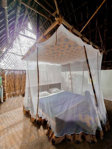 a bed with a canopy in a room at Pangani Cliffs Lodge in Pangani