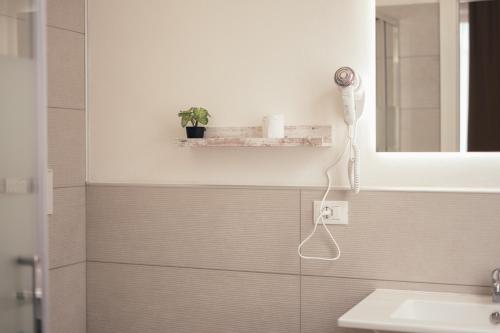 een badkamer met een wastafel en een haardroger aan de muur bij La Piccola Lady in La Spezia