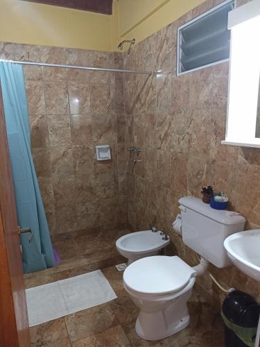 y baño con aseo, lavabo y ducha. en Alojamiento céntrico florida en Puerto Iguazú