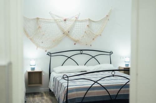 Un dormitorio con una cama negra con cortinas encima. en La Piccola Lady, en La Spezia