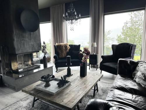 a living room with a table and a fireplace at Black pearl - Villa with a view in Grenivík
