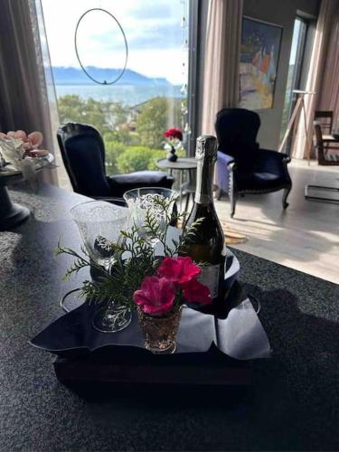 a bottle of wine and flowers on a table at Black pearl - Villa with a view in Grenivík