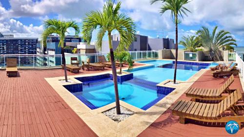 una piscina en la azotea de un edificio con palmeras en Vacanze - Austrália (JTR) en Maceió