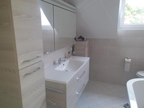 a white bathroom with a sink and a mirror at FeWo beim Oldtimer in Rees