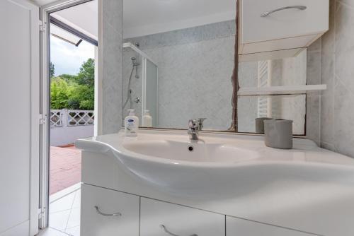 La salle de bains blanche est pourvue d'un lavabo et d'une fenêtre. dans l'établissement Wilma Apartment, à Calenzano