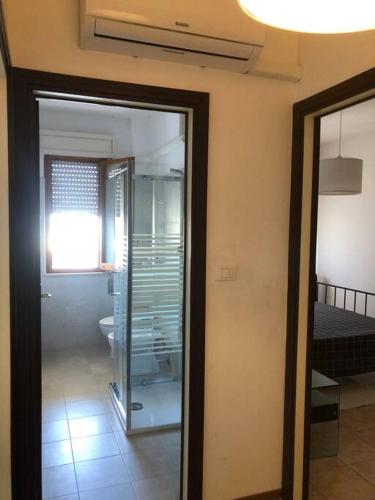 um quarto com uma porta de vidro que leva a uma casa de banho em La casa sul mare em Silvi Paese
