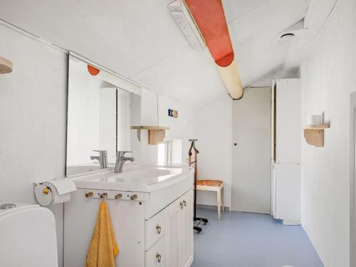 a white bathroom with a sink and a mirror at Embracing nature's Swedish house in Ludvika