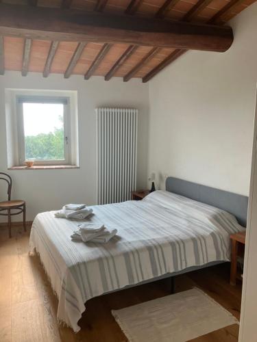 a bedroom with a bed and a window at Podere La Croce Toscana in Solata