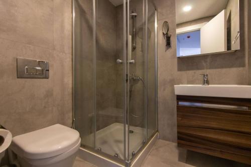 ein Bad mit einer Dusche, einem WC und einem Waschbecken in der Unterkunft Trendy & Compact 2BR Apartment w/ Free Parking #18 in Istanbul