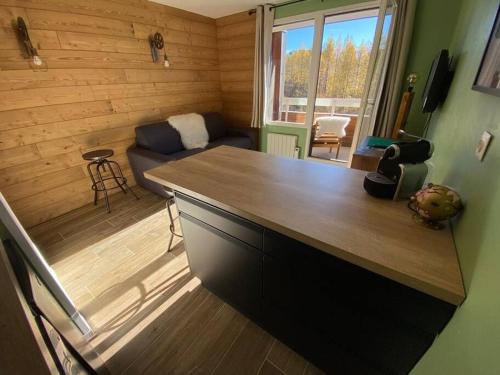 a kitchen with a counter top and a living room at Au pied des pistes avec parking Entièrement rénové in LʼHuez