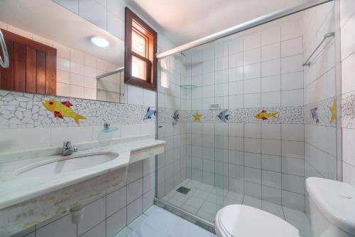 y baño con lavabo, aseo y espejo. en Pousada Mares Do Forte, en Praia do Forte