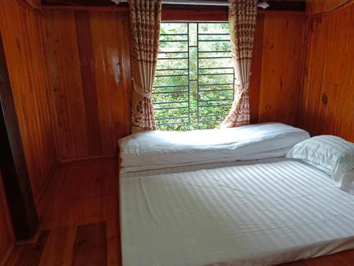 a bed in a room with a window at homestay phô núi suôi giang in Yên Bái
