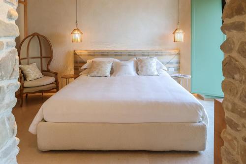 sypialnia z dużym białym łóżkiem i krzesłem w obiekcie Hidden Gabicce w mieście Gabicce Mare