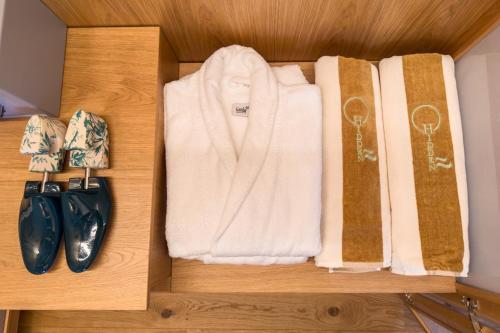 a wooden shelf with towels and a pair ofippers at Hidden Gabicce in Gabicce Mare